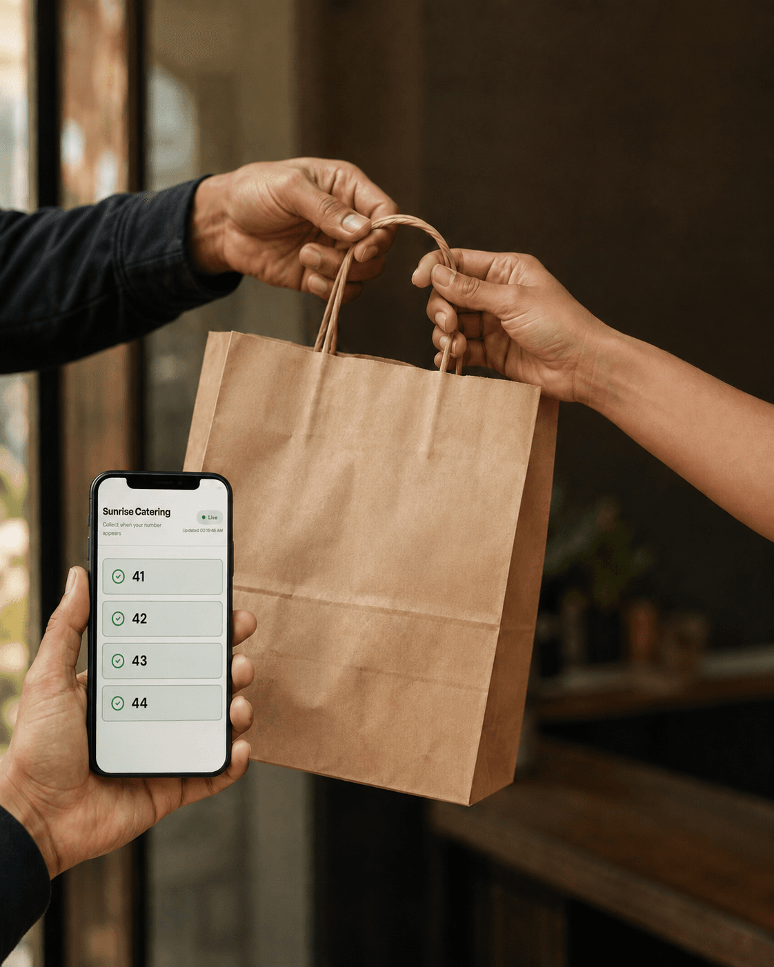 A kraft bag passing between a courier's hands and a customer's, cropped tight with no faces.